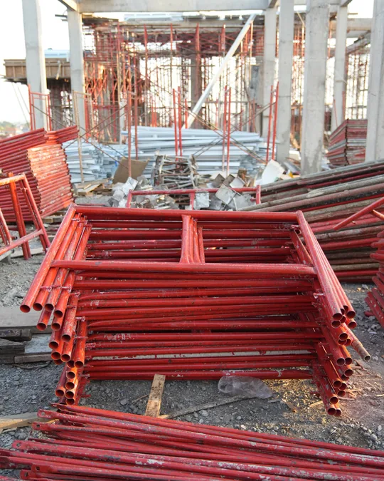 Tumpukan rangka frame scaffolding merah di area kerja SMPN 1 Kuta Utara